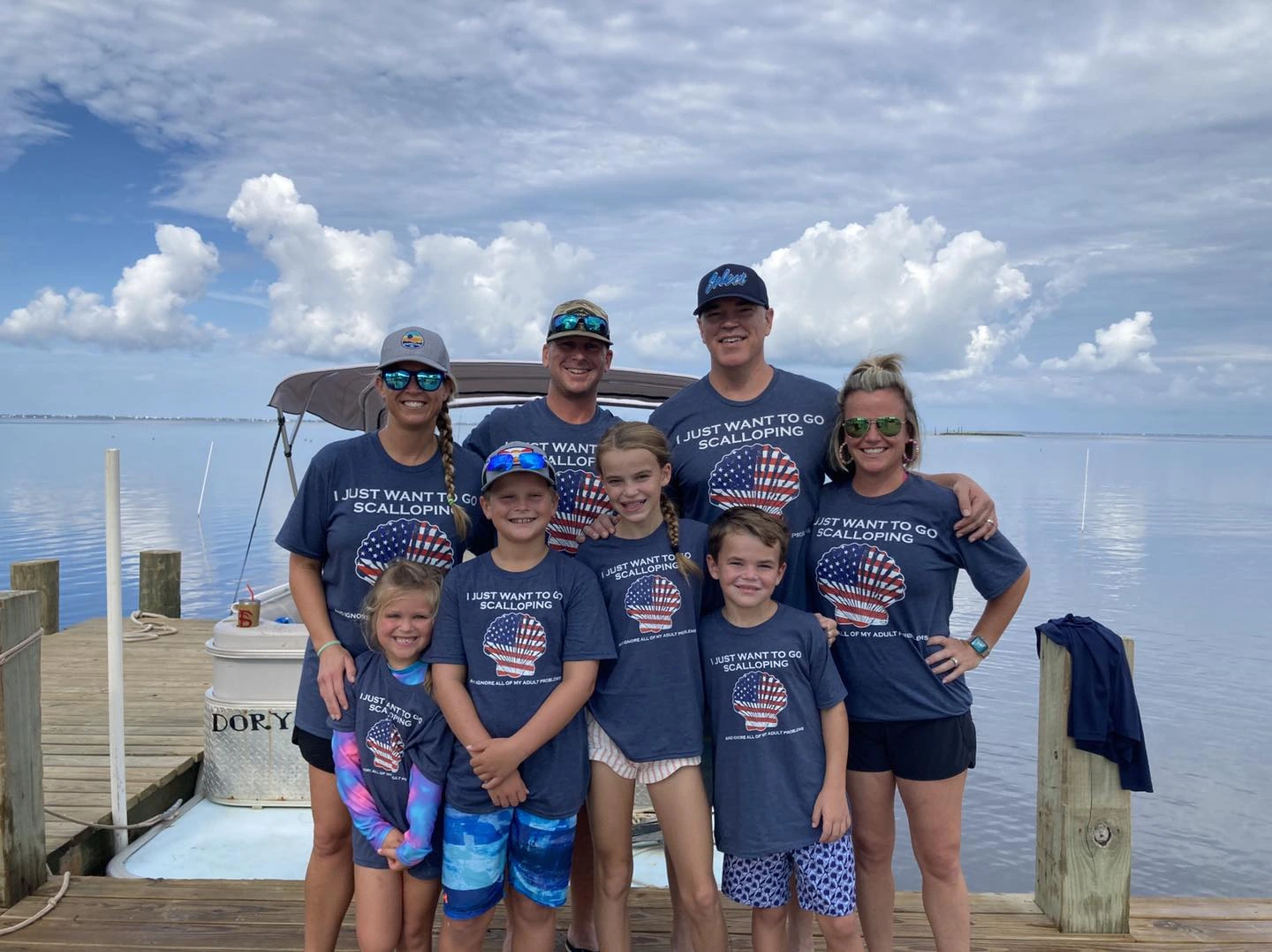 a family taking a group photo in front of a rental boat in port st. joe florida