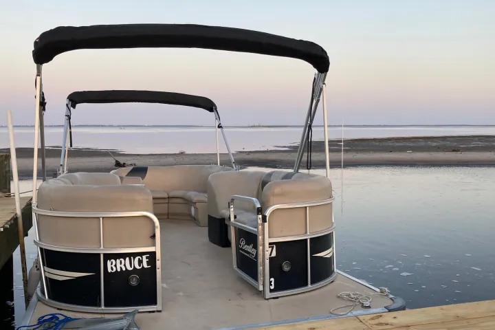 luxury pontoon boat in water with the sunset at port st. joe florida